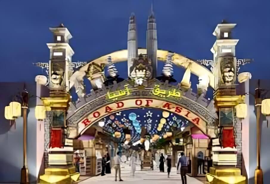 Entrance to the 'Road of Asia' at Global Village Dubai, featuring cultural architecture, lantern decorations, and evening market vibes.