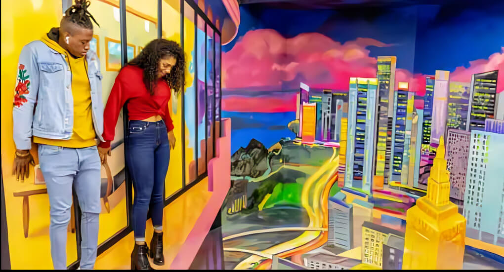 Visitors interacting with a gravity-defying illusion at the Museum of Illusions Dubai, featuring a vibrant cityscape backdrop and mind-bending visual effects.