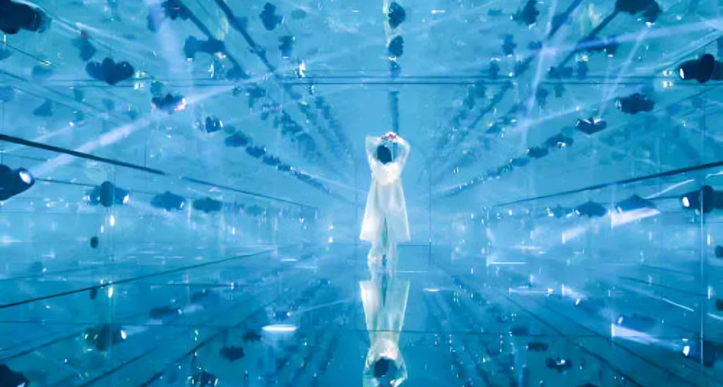 Visitor inside a dazzling mirrored room with immersive lights and reflections at AYA Universe Dubai.