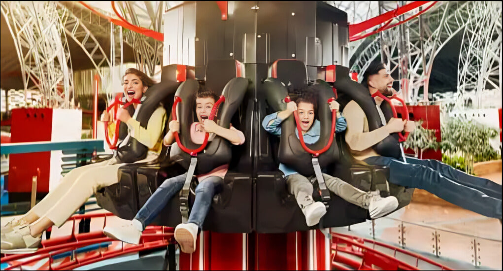 Excited family enjoying a thrilling vertical ride at Ferrari World Abu Dhabi, surrounded by vibrant red and modern design.