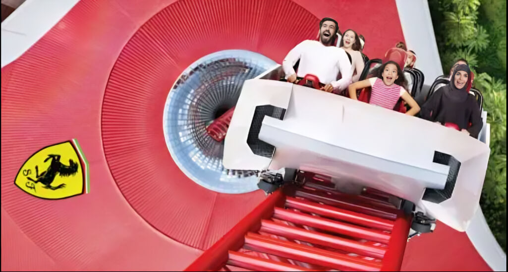 Smiling family enjoying an adrenaline-pumping roller coaster ride at Ferrari World Abu Dhabi, with the iconic red Ferrari emblem in the background.
