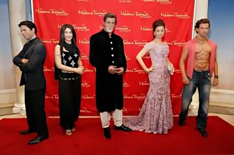 Bollywood celebrity wax statues on display at Madame Tussauds Dubai, with a red carpet backdrop for a glamorous photo experience.