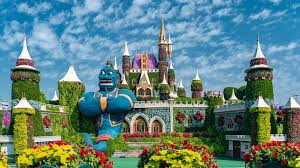 Floral castle with Aladdin's Genie topiary surrounded by vibrant flowers at Dubai Miracle Garden, under a bright blue sky.